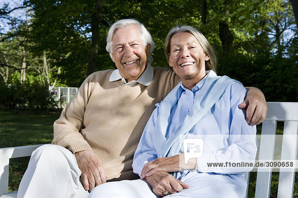 A senior couple sitting on a bench together