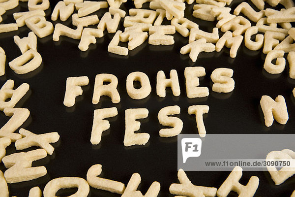 Buchstabenkekse  die den deutschen Ausdruck Frohes Fest buchstabieren.