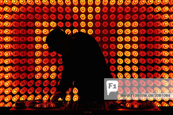 A DJ scratching a record in a nightclub