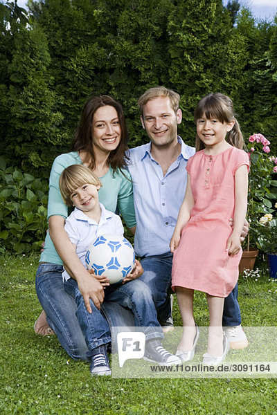Ein Porträt eines mittleren erwachsenen Paares und seiner zwei kleinen Kinder