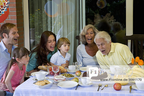 Eine Mehrgenerationen-Familie feiert Geburtstag  im Freien