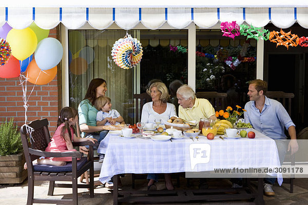 Eine Mehrgenerationen-Familie beim Frühstücken im Freien