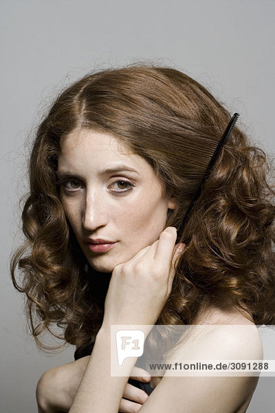 Portrait of a young woman combing her hair