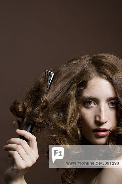 Porträt einer jungen Frau beim Haareputzen