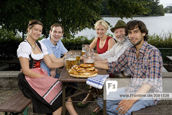 Fünf Personen sitzen in einem Biergarten
