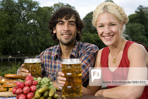 Ein Mann und eine Frau sitzen in einem Biergarten.