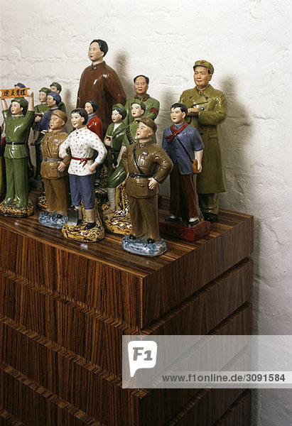 Kommunistische Keramikfiguren auf einem Holzschrank angeordnet