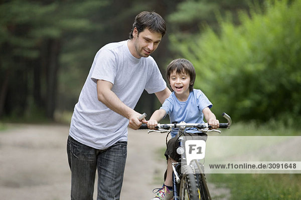 A father teaching his son to ride a bicycle