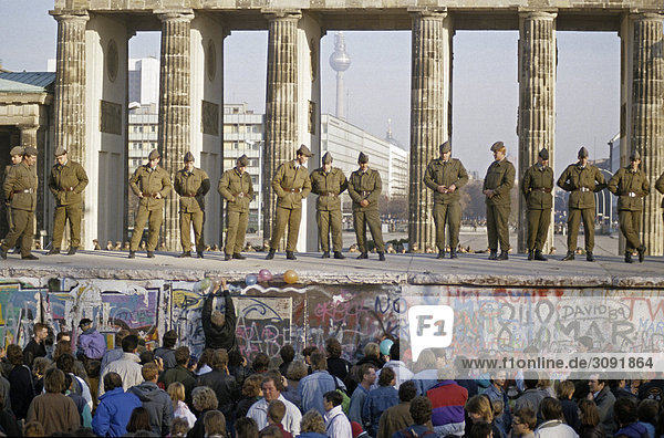 Fall der Berliner Mauer: Grenzsoldaten der nationalen Volksarmee sichern die Mauer am Brandenburger Tor. Berlin  Deutschland