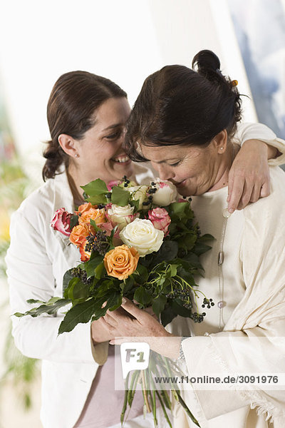 Tochter schenkt ihrer Mutter Blumen