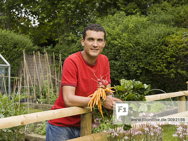 Mann im Garten mit Gemüse