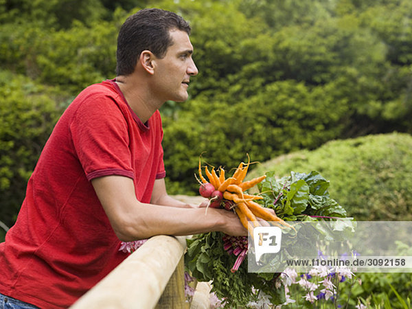 Mann im Garten mit Gemüseanbau