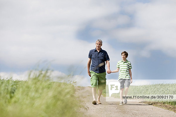 Father and son walking down a road