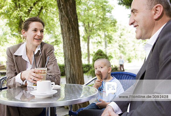 Geschäftspaar mit Sohn im Außencafé
