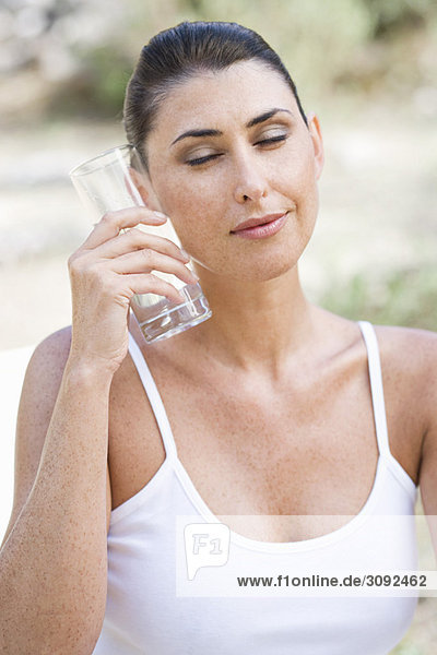 Eine weibliche Schönheit  die ein Glas Wasser hält.