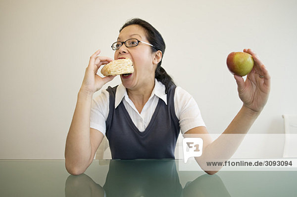 Eine Geschäftsfrau  die ein Sandwich isst.