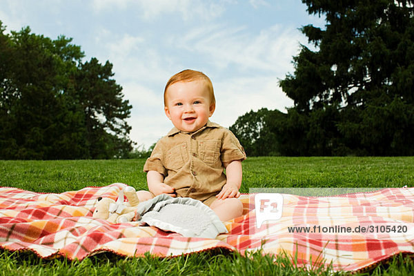 Baby Junge auf Decke im Park