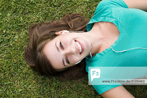 Girl on grass wearing earphones