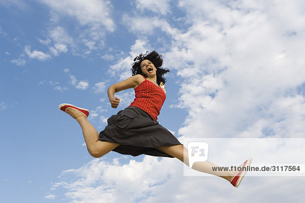Junge Frau beim Springen in der Luft  Blickwinkel niedrig