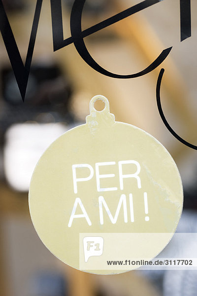 Schild in Form eines Weihnachtsschmucks im Schaufenster mit der Aufschrift per a mi  ( für mich auf Katalanisch) .