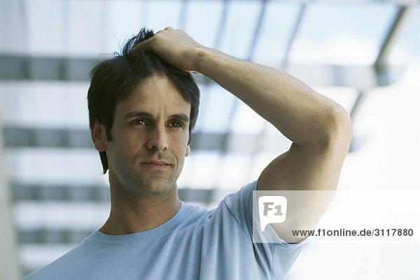 Man with hand on head thoughtfully looking away  portrait