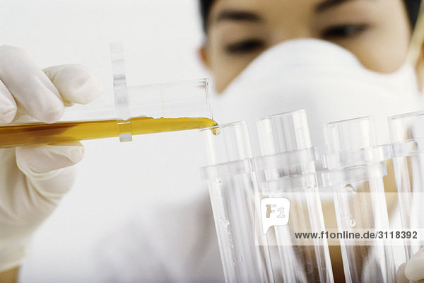 Labortechniker beim Überführen der Flüssigkeit in das Reagenzglas