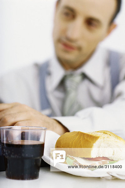 Geschäftsmann mit Schwerpunkt Arbeit Mittagessen im Vordergrund