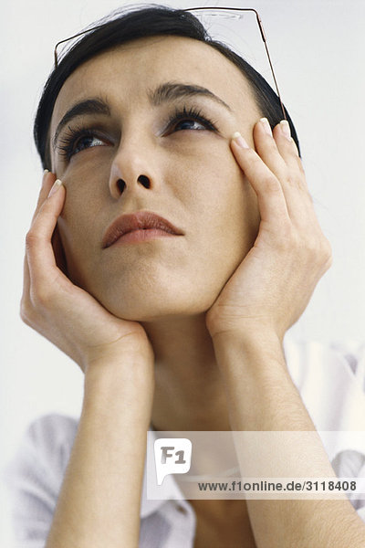 Woman holding head  looking up
