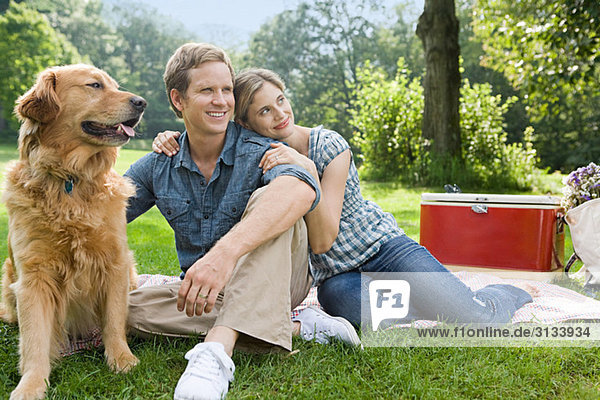 Couple having picnic with their dog