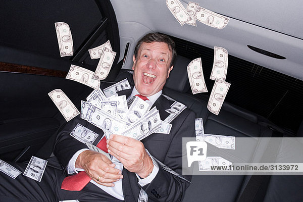 Businessman in car with bank notes
