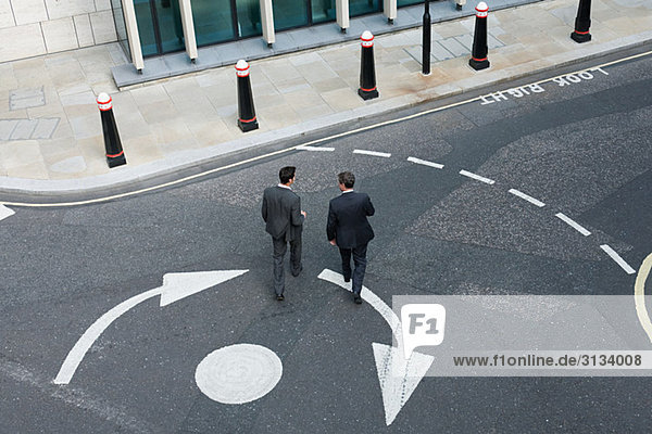 Two businessmen crossing the road