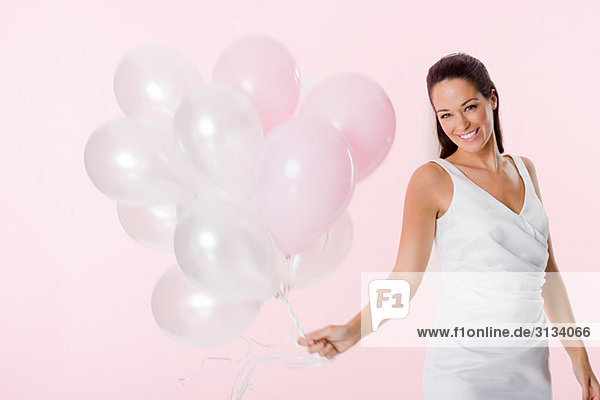 Bride holding a bunch of balloons