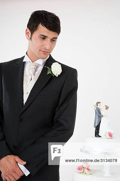 Worried looking groom with wedding cake