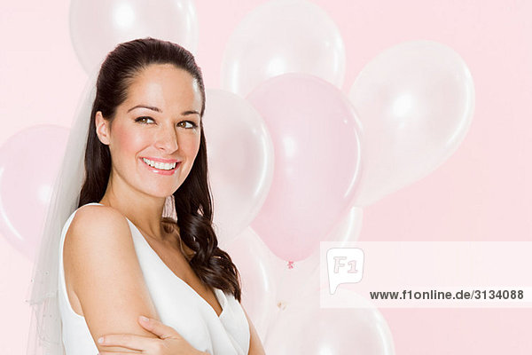 Lächelnde Braut mit einem Haufen Luftballons
