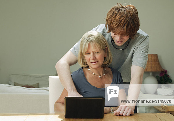 Sohn hilft Mutter mit Laptop