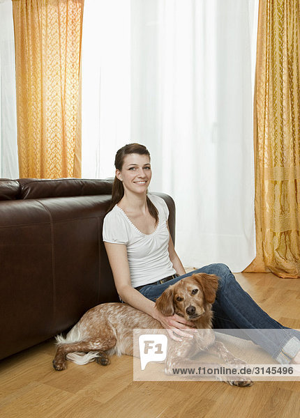 Junge Frau  Hund neben ihr sitzend