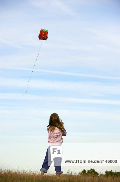 Girl flying a kite in a field