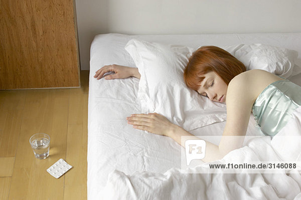 schlafende Frau im Bett mit Tabletten