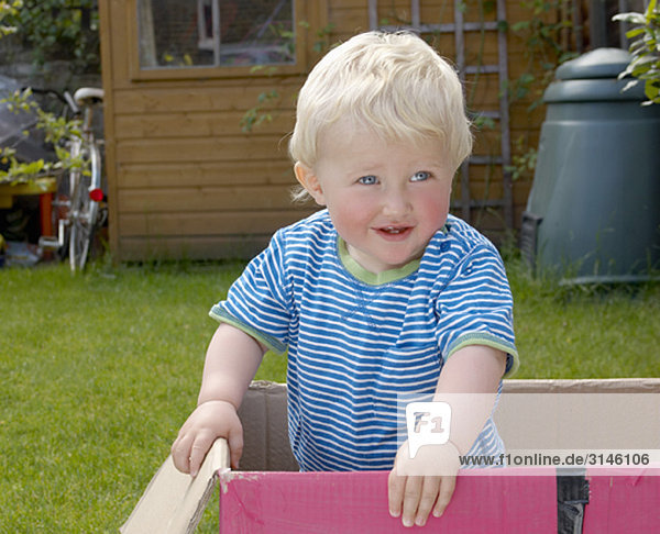 young boy standing in cardboard box