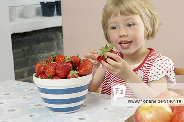 young girl eating strawberries