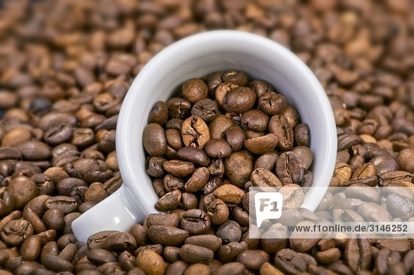 Kaffeebohnen mit liegender Espressotasse