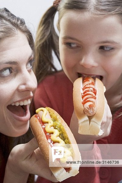 Frau und Mädchen beim gemeinsamen Hot Dog essen