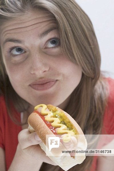 Nachdenkliche Frau mit Hot Dog