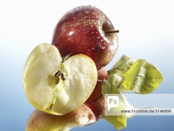 Ganzer und halber Apfel mit Blättern