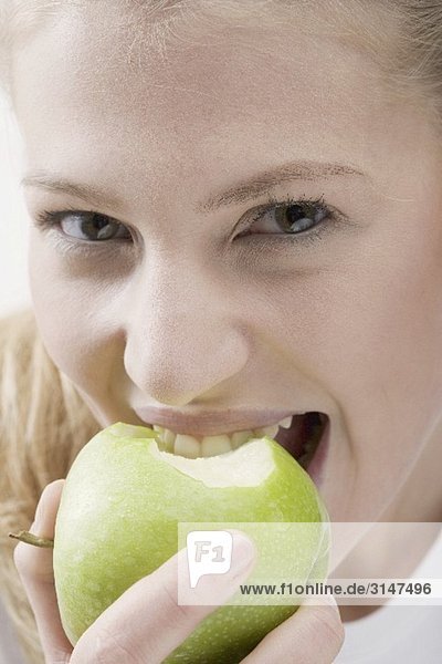 Frau isst grünen Apfel