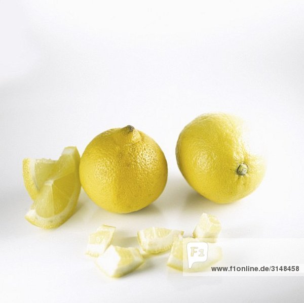 Zwei Zitronen und Zitronenstücke
