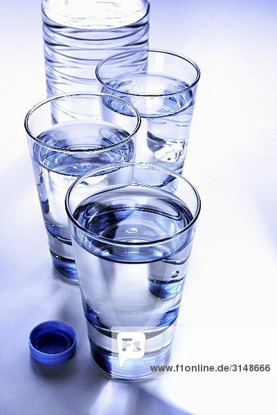 Drei Gläser Mineralwasser mit Flasche