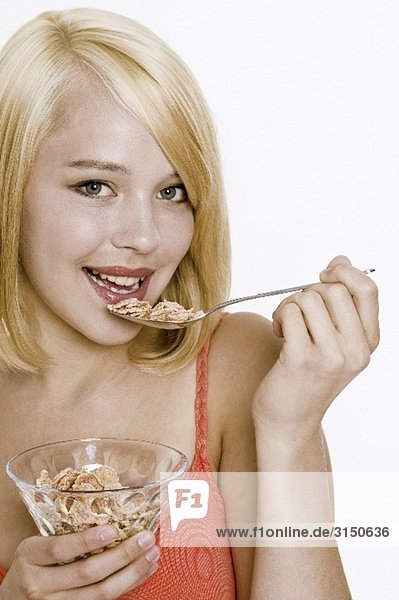 Young woman eating cornflakes