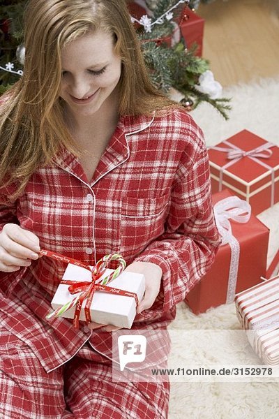 Frau öffnet Weihnachtspäckchen