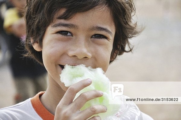 Boy eating green candyfloss